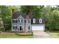 Charming two-story home with blue siding, black shutters, and a well-manicured lawn, offering classic curb appeal at 211 Southfork Dr, Belmont, NC 28012
