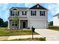 New two-story home featuring a two car garage, stone accents, and a well manicured lawn at 215 Lake George Dr, Shelby, NC 28152