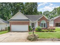 Charming single-story brick home with a well-maintained lawn and attached two-car garage at 2333 Wednesbury Ct, Kannapolis, NC 28083