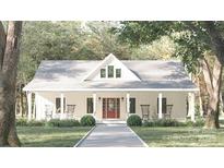 Charming white farmhouse with inviting front porch and lush landscaping, perfect for relaxing and enjoying the outdoors at 237 Roxboro Dr, Mount Gilead, NC 27306