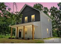 Charming two-story home boasts a welcoming front porch with wood columns and a modern two-tone facade at 25 Mickley Ave, Bessemer City, NC 28016