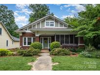 Charming brick home featuring a beautifully landscaped front yard and inviting screened-in porch at 255 South Academy St, Mooresville, NC 28115
