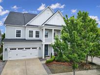 Charming two-story home with a well-manicured lawn, a two-car garage, and stylish architectural details at 295 Helton Ln, Fort Mill, SC 29708
