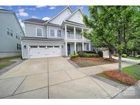 Charming two-story home with a welcoming front porch, landscaped yard, and a two-car garage at 295 Helton Ln, Fort Mill, SC 29708