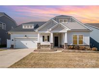 Charming single-Gathering home boasts a manicured lawn, stone accents, and a two-car garage at 3105 Bonterra Blvd, Indian Trail, NC 28079