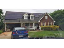 Charming two-story brick home with solar panels and welcoming front porch, ready for modern living at 4239 Saquache Dr, Charlotte, NC 28269