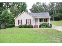 Charming single-story home with light siding, red shutters, and a well-maintained front yard at 517 N Pine Ln, Wadesboro, NC 28170