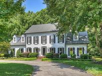 Stately two-story home with black shutters, mature landscaping and a curved driveway at 5308 Sunningdale Dr, Charlotte, NC 28277