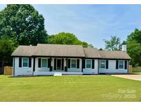 Charming ranch-style home with a well-manicured lawn and a welcoming front entrance at 554 Isle Of Pines Rd, Mooresville, NC 28117