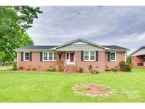 Charming brick home with a well-manicured lawn, inviting front porch, and beautiful landscaping at 622 University Dr, Rock Hill, SC 29730