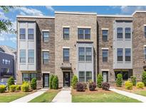 Modern brick townhome featuring gray accents, well-maintained landscaping and inviting entrance ways at 625 Uwharrie River Rd, Charlotte, NC 28211