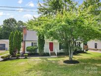 Charming home with lush landscaping, a red door, and a welcoming front yard creating an inviting curb appeal at 6412 Sullins Rd, Charlotte, NC 28214