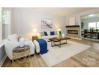 Bright living room featuring a stone fireplace, neutral decor, and wood-look flooring at 8611 Earthenware Dr, Charlotte, NC 28269
