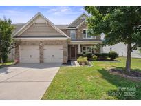 Charming two-story home featuring a manicured lawn, a two-car garage, and stone and siding accents at 10211 Snowbell Ct, Charlotte, NC 28215