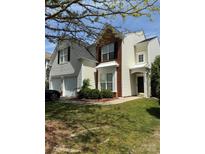 Charming two-story home featuring a manicured lawn, attached two car garage and traditional architectural design at 10826 Claude Freeman Dr, Charlotte, NC 28262