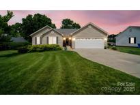Charming single-story home featuring a well-manicured lawn and an attached two-car garage with a beautiful sunset backdrop at 1505 Moss Springs Rd, Albemarle, NC 28001