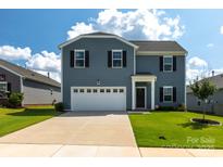 Charming two-story home with a well-maintained lawn, a two-car garage, and a welcoming front entrance at 177 Willow Valley Dr, Mooresville, NC 28115