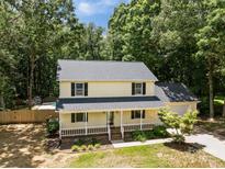 Two-story house features a charming front porch, mature trees, and a partially fenced backyard with an in-ground pool at 219 Proctor Dr, Salisbury, NC 28147