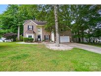 Charming two-story brick home with a well-maintained lawn and mature trees at 2426 Tory Oak Pl, Matthews, NC 28105
