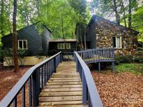 Stunning exterior showcasing a home with a stone facade and a charming wooden walkway at 2800 Patio Ln, Gastonia, NC 28056