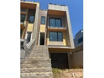Modern two-story home featuring large windows, gray stone, and a convenient attached garage at 312 Wesley Heights Way # B, Charlotte, NC 28208