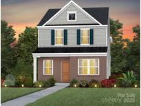 Charming two-story home with a brick facade, gray siding, and a well-manicured lawn at 3628 Pamlico St # 122, Monroe, NC 28110