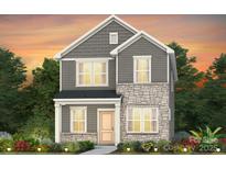 Charming two-story home boasting a mix of stone and vinyl siding, complemented by a beautifully landscaped front yard at 3632 Pamlico St # 121, Monroe, NC 28110