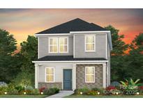 Charming two-story home featuring stone accents, a well-manicured lawn, and professional landscaping, set against a vibrant sunset backdrop at 3637 Edisto Pl # 119, Monroe, NC 28110