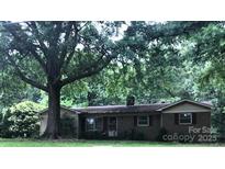 Charming single-story home with a mature tree-lined front yard and brick exterior at 3715 Vanderburg Dr, Concord, NC 28025