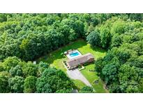 Expansive aerial view of estate home surrounded by lush greenery, pool, and a long driveway at 4916 Leepers Creek Rd, Maiden, NC 28650