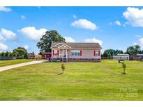 Charming single-story home featuring a sprawling green lawn and a welcoming front porch with red shutters at 509 Brawley Rd # 7, Cleveland, NC 27013