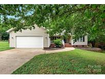 Charming one-story home featuring a well-maintained lawn and attached two-car garage at 605 Beavers Cove Nw Ln # 15, Concord, NC 28027