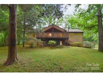 Charming home with a large deck overlooking the landscaped backyard surrounded by lush greenery and mature trees at 6227 Dogwood Ln, Waxhaw, NC 28173