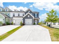 Charming townhome featuring a two-car garage, craftsman details, and a well-maintained front yard and driveway at 711 Bellmouth Rd, Clover, SC 29710