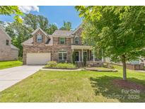 Charming two-story brick home featuring a manicured lawn and a two-car garage at 8336 Early Bird Way, Mint Hill, NC 28227