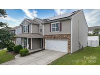 Charming two-story home with a stone-accented garage and manicured lawn at 8511 Redding Glen Ave, Charlotte, NC 28216