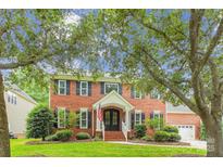 Charming brick home with a covered front porch, black shutters, and mature landscaping at 8612 Tintinhull Ln, Waxhaw, NC 28173