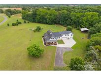 Expansive aerial view of a modern farmhouse, lush green lawn, and mature trees on a large lot at 930 Hawley Rd, McConnells, SC 29726