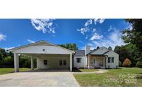 Charming single-story home featuring a carport, a manicured lawn, and inviting front porch at 1015 4Th St, Spencer, NC 28159