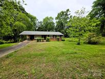 Charming single-story brick home with a carport and mature trees, offering a serene setting at 1105 Stanton Dr, Shelby, NC 28150