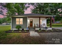 Charming home featuring a welcoming front porch, fresh landscaping, and a mix of modern and traditional design elements at 118 Globe St, Mount Holly, NC 28120