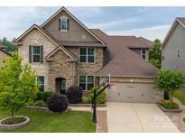 Beautiful two-story home featuring brick and stone facade, well-manicured lawn, and a two-car garage with basketball hoop at 1190 Arges River Dr, Fort Mill, SC 29715