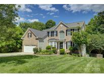 Charming two-story brick home with well-manicured lawn and lush landscaping at 12125 Mountainside Ln, Charlotte, NC 28278