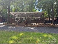 Charming covered porch home surrounded by lush trees offering shade and privacy at 146 Trivette Trl, Mount Gilead, NC 27306