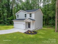 Charming two-story home featuring a spacious front yard, attached garage and simulated lawn at 1941 32Nd Ne St, Hickory, NC 28601
