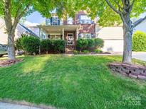 Charming two-story home with brick facade and a well-manicured lawn and mature shade trees at 2111 Elendil Ln, Charlotte, NC 28269