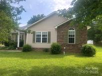 Charming single-story home with a well-manicured lawn and a mix of brick and siding exterior at 2210 Dawn Rdg, Monroe, NC 28110