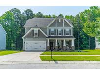 Charming two-story home featuring a well-manicured lawn and an attached two-car garage at 2714 Woodlands Creek Dr, Monroe, NC 28110