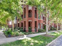 Charming brick condo building with lush landscaping and mature trees at 2810 Selwyn Ave # 104, Charlotte, NC 28209