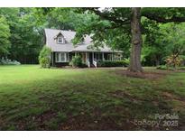 Charming home with a covered front porch and mature trees in a beautiful landscaped yard at 344 Lucas Rd, Star, NC 27356